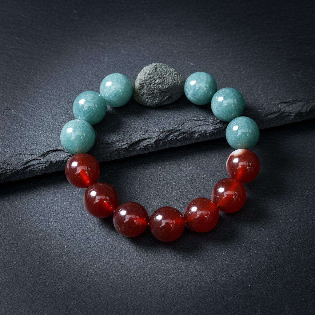 A beaded bracelet made of round polished stones, featuring teal-blue beads on one side, reddish-brown carnelian-like beads on the other, and a dark gray stone in the center, displayed on a weathered wood surface.